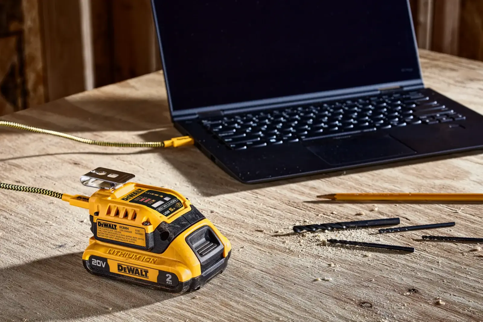 Kit de carga USB de DEWALT conectado a una laptop sobre una superficie de contrachapado