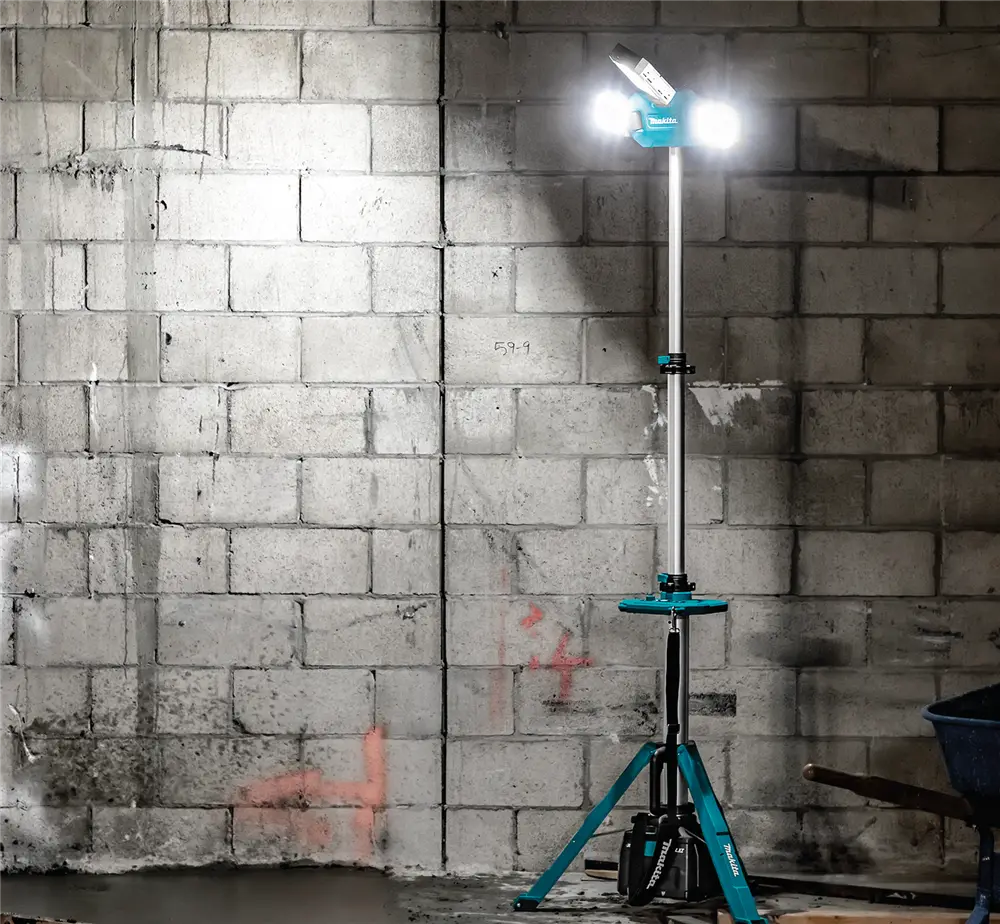 Lampe tour à pleine hauteur éclairant un mur de blocs de béton