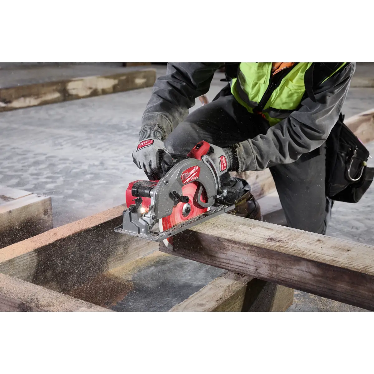 Carpenter in a hi-vis vest cutting a timber beam with the saw