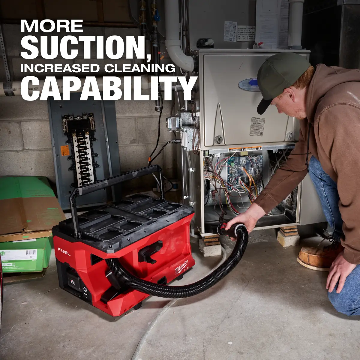 Worker using the Milwaukee M18 FUEL 4-gallon vacuum near a furnace