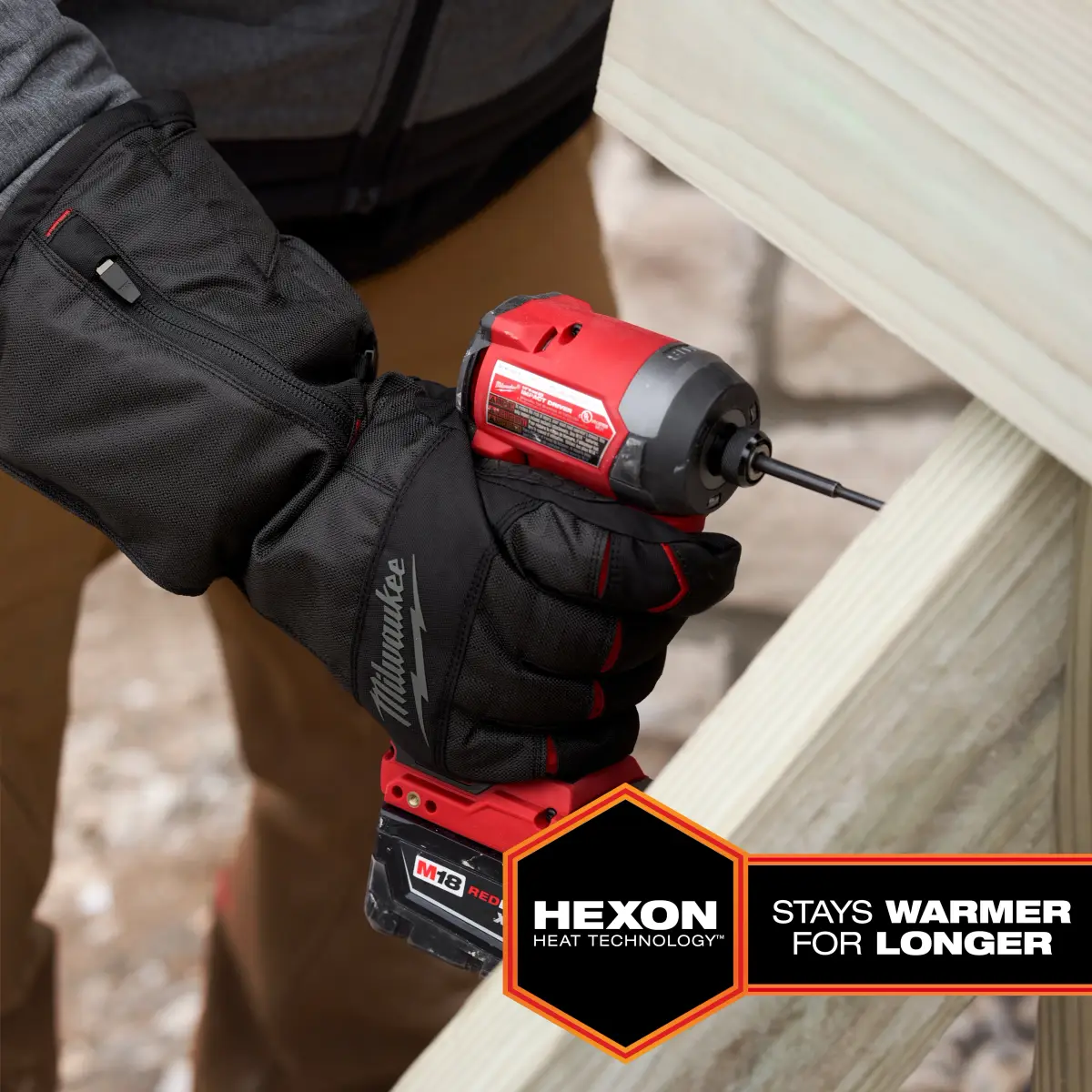 Worker wearing the heated glove while driving a screw with an impact driver