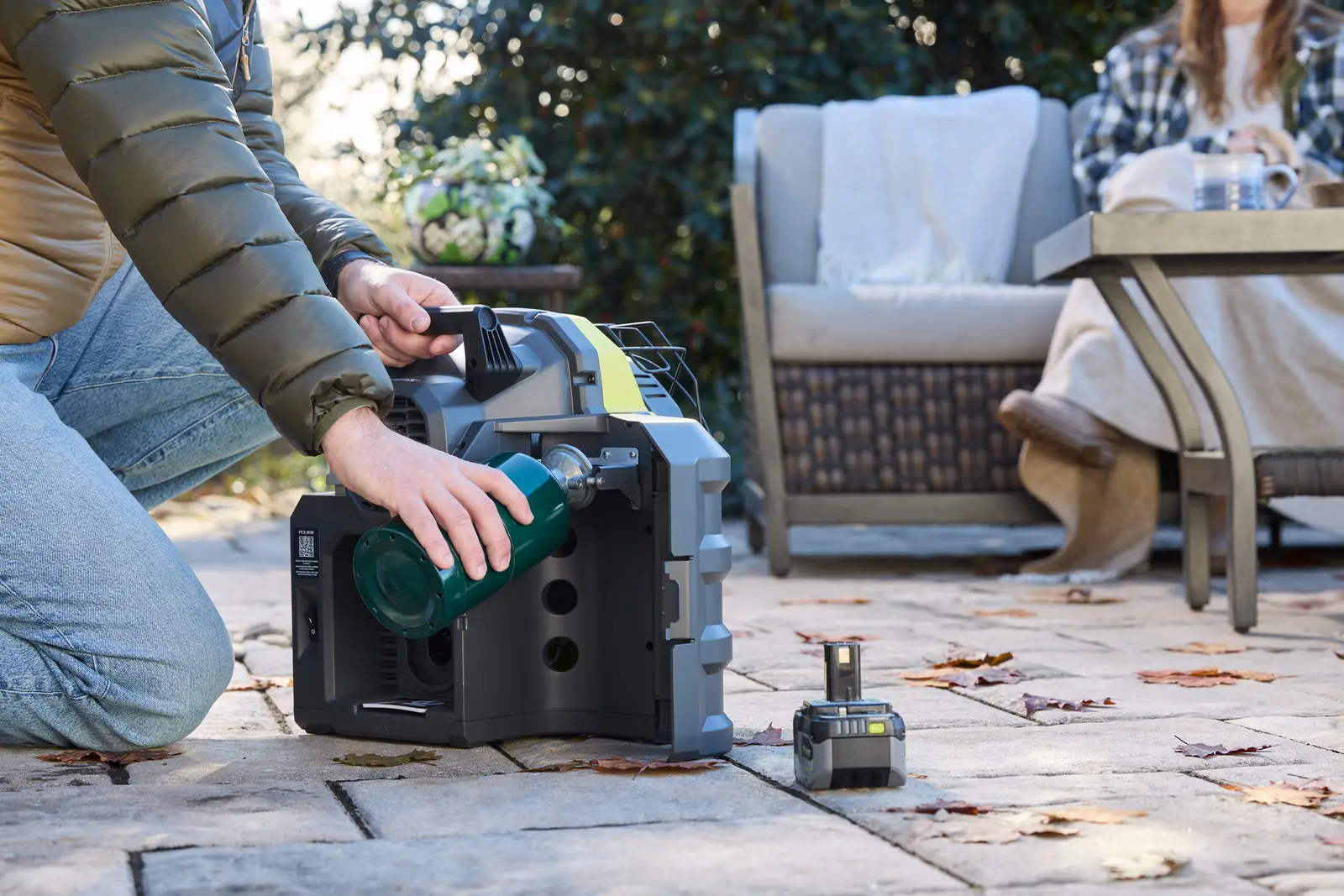 工人在露台上為 Ryobi 18V ONE+ 便攜暖風機接上丙烷氣瓶
