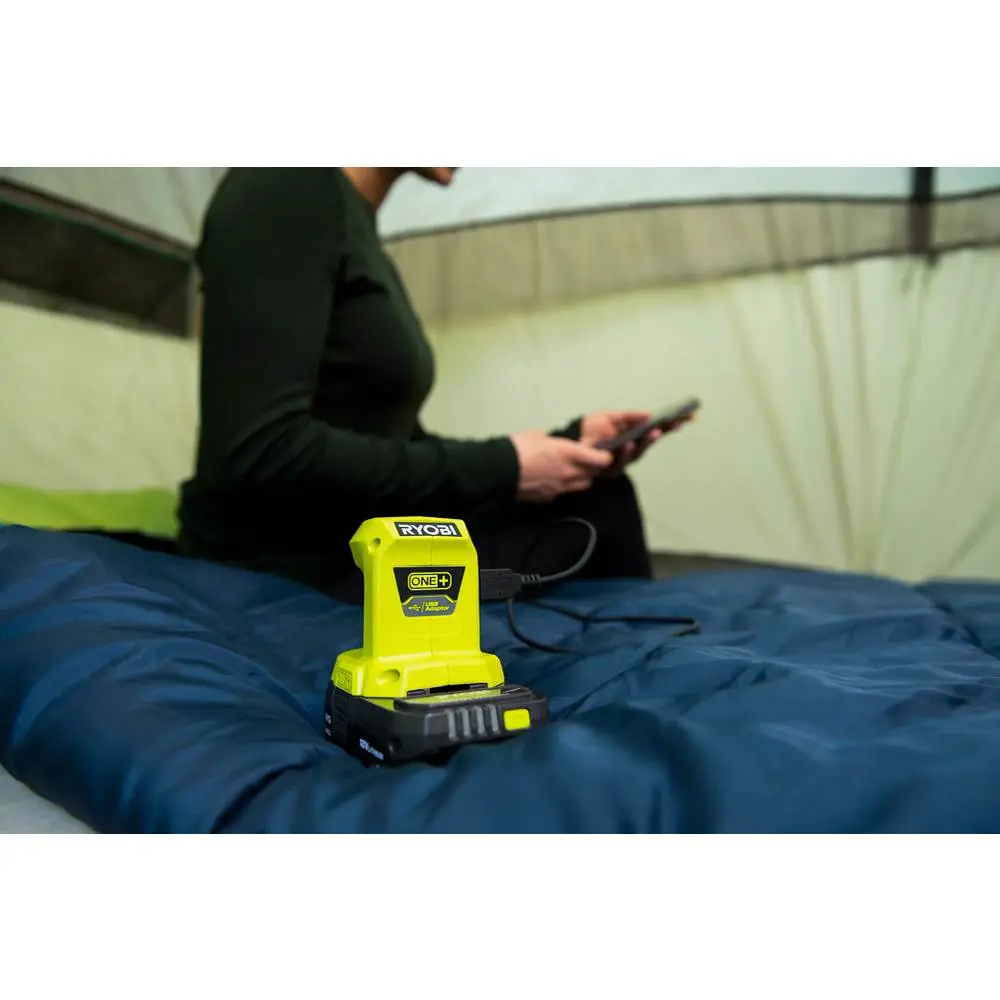 Nguồn điện Ryobi ONE+ đang sạc điện thoại trong lều